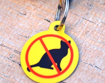 May include: Yellow round pet tag with a red circle and a black silhouette of a cat with a red line through it. The text "No Cats" is not visible.