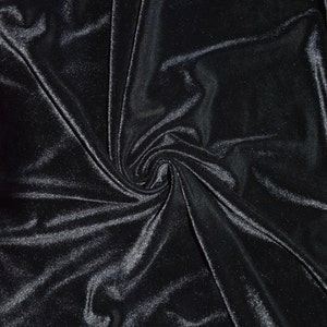 May include: Black velvet fabric with a soft, smooth texture. The fabric is draped and folded, creating a swirling pattern.