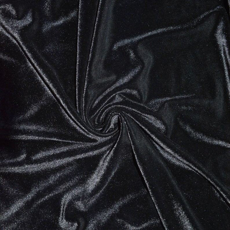 May include: Black velvet fabric with a soft, smooth texture. The fabric is draped and folded, creating a swirling pattern.