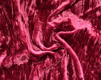 May include: Close-up of a deep red velvet fabric with a soft, plush texture. The fabric is draped and folded, creating a luxurious and elegant look.