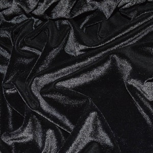May include: Black velvet fabric with a smooth, shiny texture. The fabric is draped and folded, creating a luxurious and elegant look.