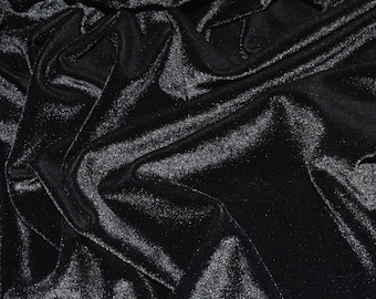 May include: Black velvet fabric with a smooth, shiny texture. The fabric is draped and folded, creating a luxurious and elegant look.