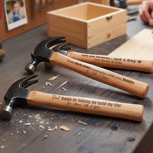 May include: Three claw hammers with black metal heads and light wood handles. Each handle features custom laser-engraved text: Love you Forever... and a Day, Love BUILDING memories with you, DAD!, and Dad, thanks for helping me build my life!