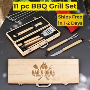 Puede incluir: Un juego de parrilla de barbacoa de 11 piezas en una caja de madera. El juego incluye una espátula, pinzas, cepillo, tenedor, cuchillo y brochetas. La caja está grabada con "DAD'S GRILL" y un gráfico de llama. Las herramientas tienen mangos de madera y cabezas de acero inoxidable.