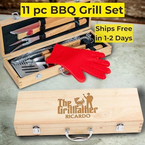 May include: An 11-piece BBQ grill set presented in a wooden case. The set includes grilling tools, a red heat-resistant glove, and a wooden case with the text "The Grillfather Ricardo". The top of the case has the text "11 pc BBQ Grill Set".