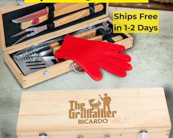 Puede incluir: Un juego de parrilla de 11 piezas en una caja de madera. El juego incluye herramientas para asar, un guante rojo resistente al calor y una caja de madera con el texto "The Grillfather Ricardo". La parte superior de la caja tiene el texto "11 pc BBQ Grill Set".