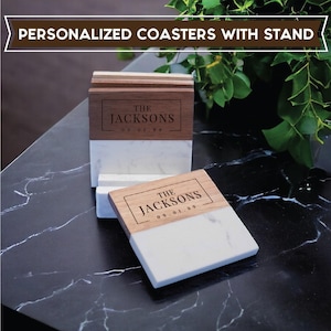 May include: Personalized coasters with a stand. The coasters have a wooden top with the name "The Jacksons" and the date "09.01.99" engraved on them. The bottom half is white marble. The stand is made of wood and marble.