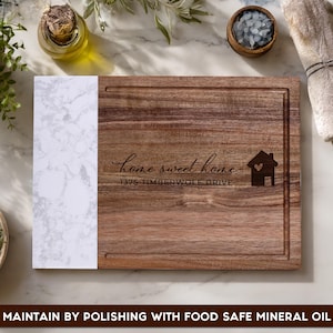 Custom laser engraved walnut and marble cutting board featuring a personalized home address and "Home Sweet Home" design. Personalized charcuterie board gift for new homeowners, housewarming parties, weddings, anniversaries, and real estate closing gifts.