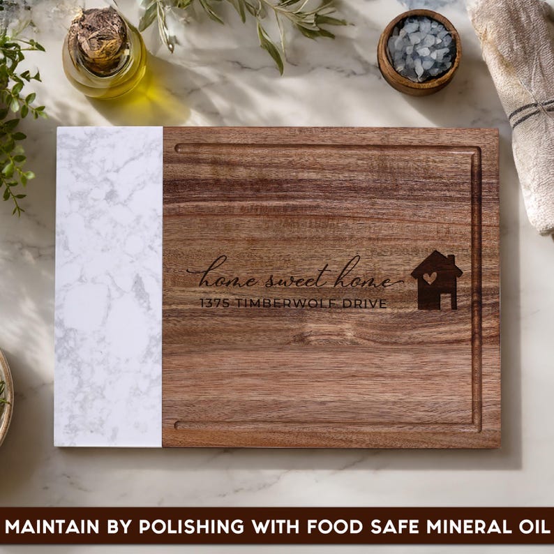 Custom laser engraved walnut and marble cutting board featuring a personalized home address and "Home Sweet Home" design. Personalized charcuterie board gift for new homeowners, housewarming parties, weddings, anniversaries, and real estate closing gifts.