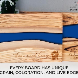 K&ouml;nnte beinhalten: Zwei Holzschneidebretter mit einem blauen Harzfluss-Design. Ein Brett ist mit "home sweet home" und einer Adresse graviert. Das andere Brett ist mit "The Nelsons" graviert. Der Text "EVERY BOARD HAS UNIQUE GRAIN, COLORATION, AND LIVE EDGE" steht unten.