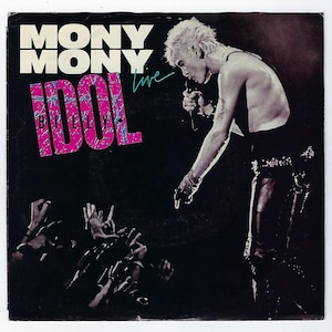 Puede incluir: Una fotografía en blanco y negro de Billy Idol actuando en vivo. La imagen muestra a Idol cantando en un micrófono con el brazo extendido. El texto "Mony Mony Billy Idol Live" está impreso en rosa y azul sobre un fondo negro.