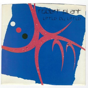 May include: A blue and white record cover with a pink abstract design and white, red, and black dots. The text "robert plant little by little" is printed on the cover.