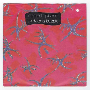 May include: A pink and black single record sleeve with a black and white graphic design of abstract shapes. The text "robert plant pink and black" is printed on the front of the sleeve.