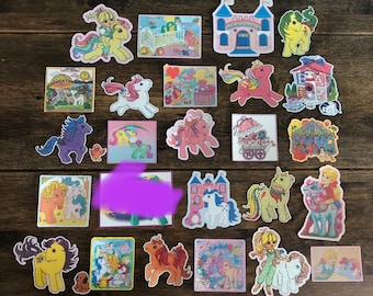 May include: A collection of vintage My Little Pony stickers featuring various ponies, castles, and other scenes. The stickers are colorful and feature a variety of characters and designs.