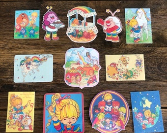 Puede incluir: Un conjunto de 11 pegatinas vintage con personajes de la caricatura Rainbow Brite. Las pegatinas son coloridas y presentan una variedad de personajes, incluyendo Rainbow Brite, sus amigos y sus enemigos. Las pegatinas están en buen estado y serían una gran adición a cualquier colección.
