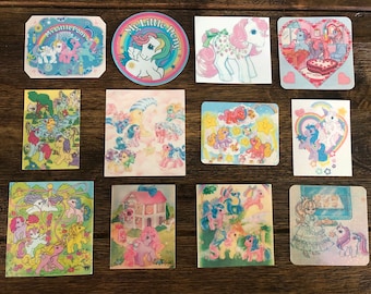 May include: A collection of 12 My Little Pony stickers featuring various scenes and characters. The stickers are colorful and feature a variety of pastel colors, including pink, blue, yellow, and purple. The stickers are perfect for adding a touch of whimsy to any project.