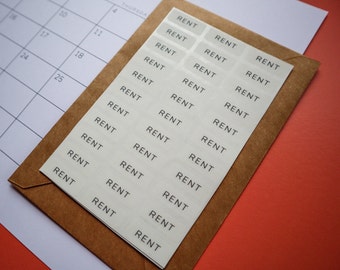 May include: A brown envelope with white stickers that say "RENT" on them. The stickers are arranged in rows and columns.