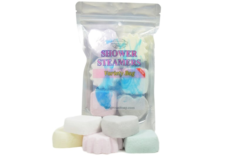 May include: A clear plastic bag filled with a variety of colorful shower steamers in heart and flower shapes. The bag has a label that reads "Shower Steamers Variety Bag".
