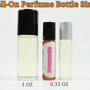 May include: Three roll-on perfume bottles, one 1 oz bottle with a black cap, one 0.33 oz bottle with a black cap and a brown label that says "Honeysuckle", and one 0.33 oz bottle with a silver cap.