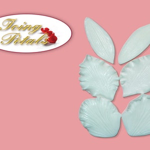 Puede incluir: Conjunto de siete moldes de pétalos de flores de silicona blanca para decorar pasteles. Los moldes tienen forma de pétalos con una superficie texturizada. Los moldes están dispuestos en un patrón que se asemeja a una flor.