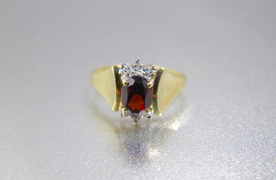 0.49 Carat ctw 10k Gold Oval Red Garnet & Diamond Bypass Swirl Cocktail Anniversary Fasion Ring 0.49 Carat ctw 10k Gold Oval Red Garnet & Diamond Bypass Swirl Cocktail Anniversary Fasion Ring
