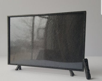 May include: A black television with a flat screen and a black remote control.