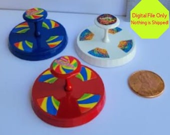 May include: Three miniature carnival ride platforms with colorful designs. The platforms are blue, white, and red with yellow and green stripes. The platforms are about the size of a US penny.