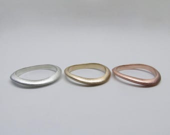 Wave rings in rose gold, yellow gold, and sterling silver. Modern curvilinear rings that can be worn nesting in a set. Size 6.