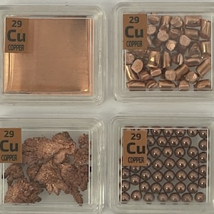 Może przedstawiać: Cztery przezroczyste plastikowe pojemniki, z których każdy zawiera inną formę miedzi. Pojemniki są oznaczone symbolem pierwiastka "Cu" i słowem "Miedź". Formy miedzi obejmują arkusz, małe kawałki, proszek i małe kule.