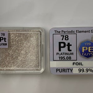 May include: A small, silver-colored piece of platinum foil in a clear plastic case. The foil is labeled with the element's symbol, atomic number, and name: "78 Pt PLATINUM". The case also includes a label with the text "The Periodic Element Guys" and a cartoon illustration of a scientist.