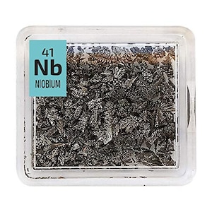 May include: A clear plastic container with a white label that reads "41 Nb NIOBIUM". Inside the container is a sample of niobium metal, which is a silvery-gray, shiny, and hard metal.