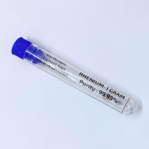 以下が含まれることがあります： 青いキャップが付いた透明なプラスチックチューブに、少量のレニウム金属が入っています。ラベルには「レニウム-1グラム 純度：99.99％」と「The Periodic Element Guys www.peguys.com」と書いてあります。