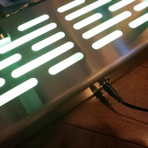 May include: A stainless steel floor mat with a green light pattern, similar to the Star Wars Millennium Falcon, and a black power cord.