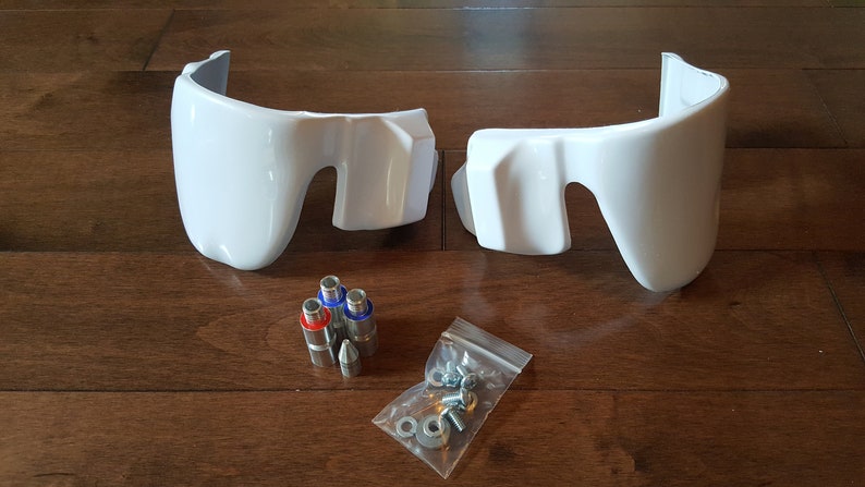 May include: Two white plastic motorcycle fairings with mounting hardware, including screws, nuts, and metal pins.