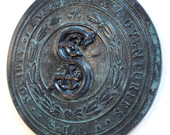 Placa de la Sociedad de Exploradores y Aventureros - S.E.A. acabado envejecido oscuro
