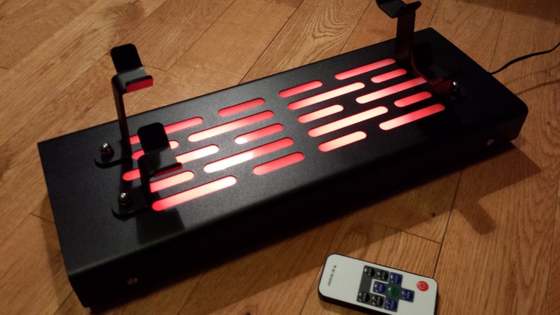 May include: A black metal stand with a red light-up panel and two metal hooks. The stand is controlled by a remote control with buttons.