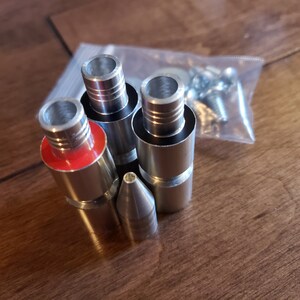 May include: A set of five silver metal attachments for a pipe, including a pointed tip and four different sized connectors with red rubber rings.