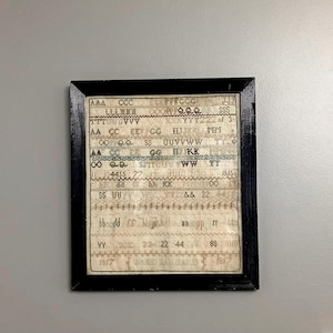 Regency sampler dated 1817 by Jane Barnard, framed cross stitch needle work, alphabet and numbers, in an antique ebonised frame with glass
