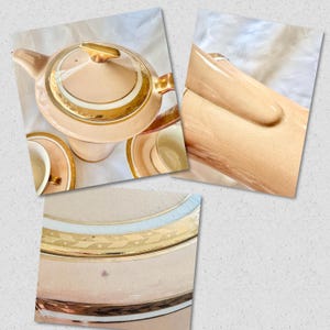 K&ouml;nnte beinhalten: Ein Vintage-Teeservice in einem sanften Pfirsichton mit goldenen Verzierungen. Das Set umfasst eine Teekanne, Tassen und Untertassen. Die Teekanne hat einen goldenen Griff und Deckel. Die Untertassen und Tassen haben einen goldenen Rand.