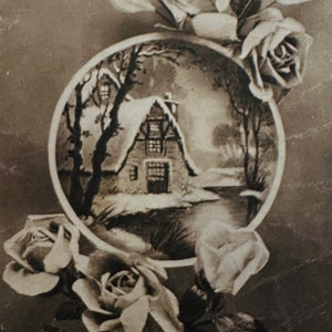 Eine vintage französische Weihnachtskarte mit einem verschneiten Cottage in einem Cameo, umgeben von Rosen.
