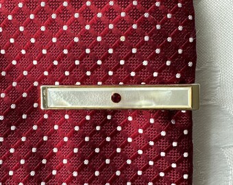 A vintage man's tie pin, gold metal. The perfect gift for a special occasion.