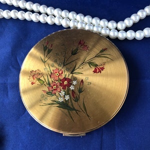 A vintage Vanity Fair of London &#39;convertible&#39; powder compact, decorated with carnations and pinks. c1950.