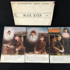 Um conjunto de 3 cartões com canções originais da Primeira Guerra Mundial - "Olhos Azuis" (4873). Feito por Bamforths de Holmfirth, Inglaterra. c. 1914.