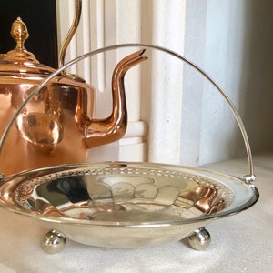 A vintage silver plated bowl with pierced detail and swing handle. Made by William Hutton and sons c1863.