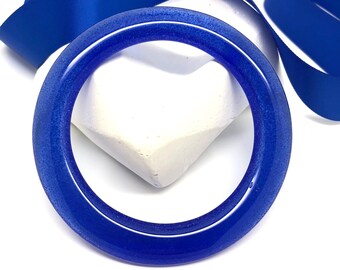 May include: A blue glass bangle bracelet with a sparkly finish.