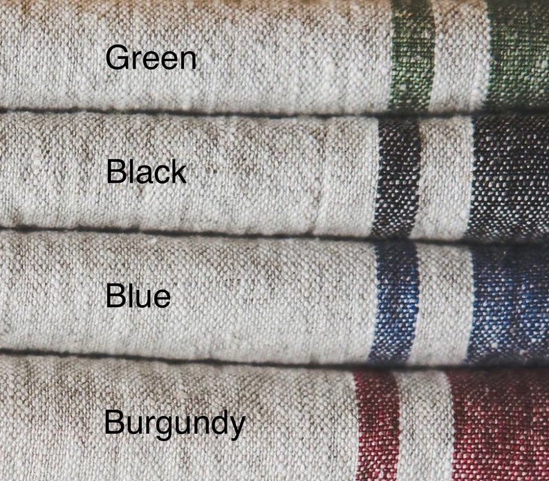 May include: Four stacked pieces of textured beige fabric, each featuring two vertical stripes in different colors. The text labels identify the colors as Green, Black, Blue, and Burgundy, corresponding to the stripe color on each fabric layer.