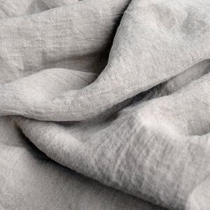 May include: A close-up of a soft, gray linen fabric with a textured, wrinkled surface.