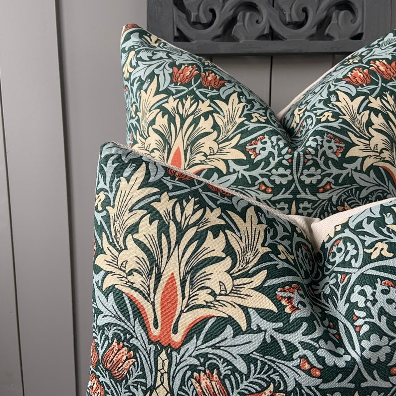 May include: Two green and cream throw pillows with a floral pattern. The pattern features stylised flowers and leaves in shades of green, cream, and orange.