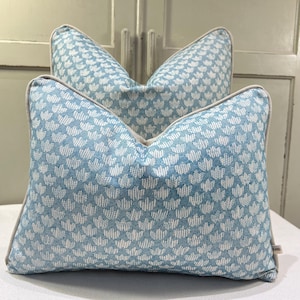 May include: Two rectangular cushions with a light blue and white floral design. The cushions have a beige border. They are made from a textured fabric, suitable for home decor and add a touch of elegance.
