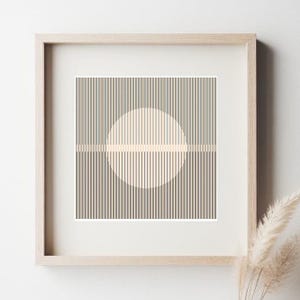 Puede incluir: Una impresión enmarcada con un diseño geométrico que presenta un círculo con líneas verticales en su interior, sobre un fondo de líneas verticales de color marrón claro.